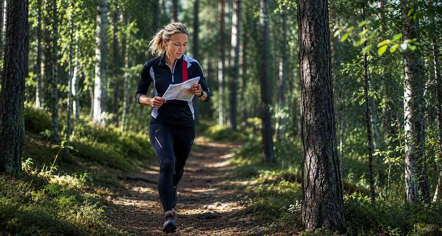 Helena ute i skogen och utför orientering