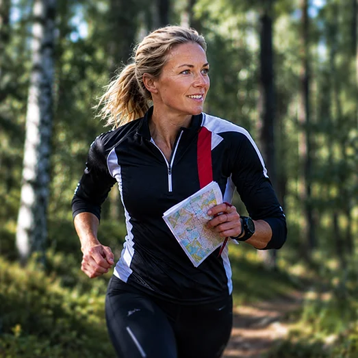 Helena utför orientering ute i skogen